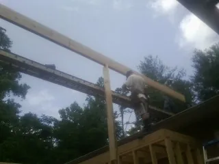 Carpenter setting a ridge beam over a new addition frame — Ice Dam Removal by Roofing Brothers in La Canada Flintridge