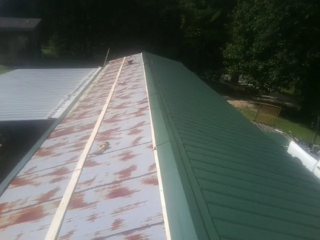 Old rusted panels beside newly installed green metal roofing — Wind Damage Roof Repair by Roofing Brothers in La Canada Flintridge