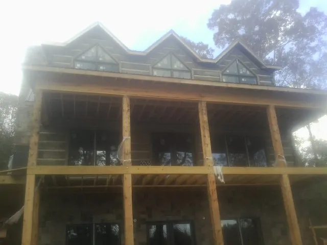 Dormers and porch framing on a large log home under construction — Roof Coating work by our crew in La Canada Flintridge