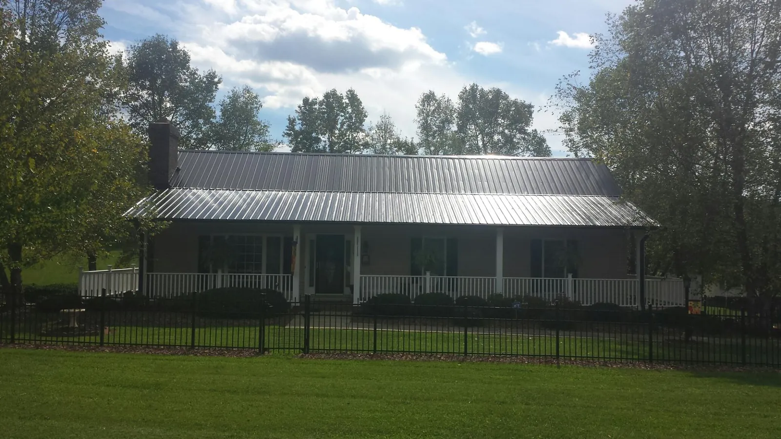 Gray metal roof on a brick ranch with a full width front porch — Gutter Guard Installation work by our crew in La Canada Flintridge
